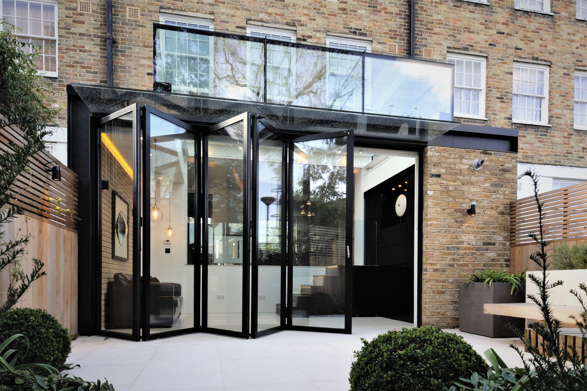 large floor to ceiling bifold doors leading to the patio on the extension of a brick house