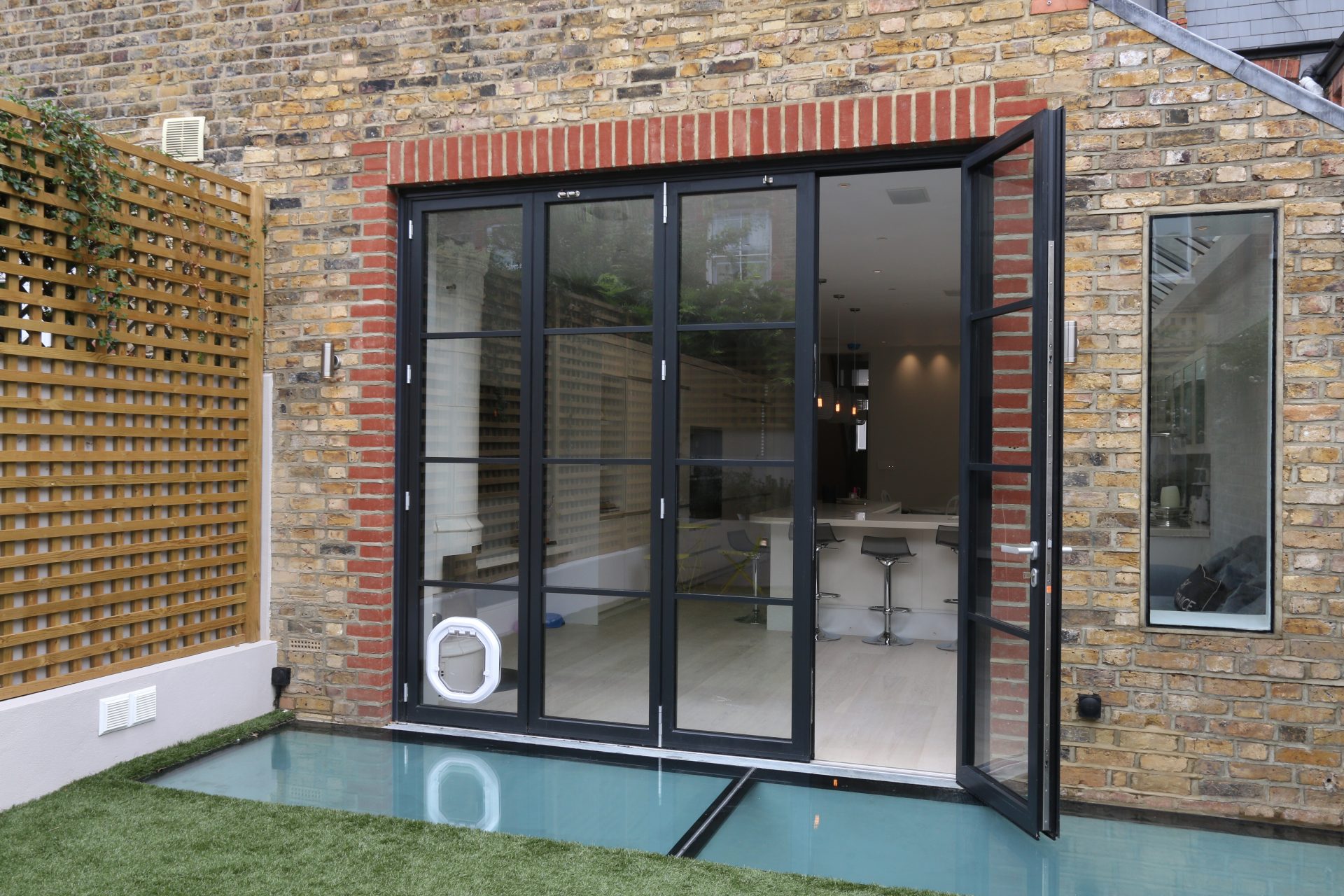 Bifold patio doors onto kitchen and glass roof featuring outside