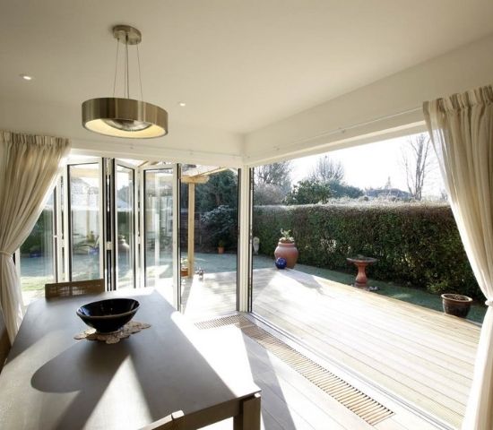 aluminium bifold doors in a corner configuration open to merge living room and external decking