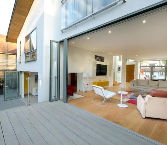 large aluminium bifold doors open to merge living room and external decking