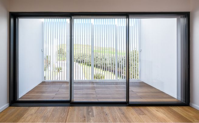 three track sliding glass door leading out to external balcony which also has wooden decking