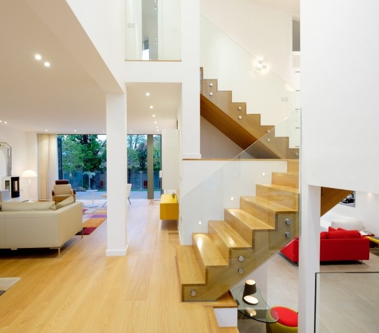 elegant interior design using light colours to make the living spaces appear bigger and a frameless glass balustrade on the stairs