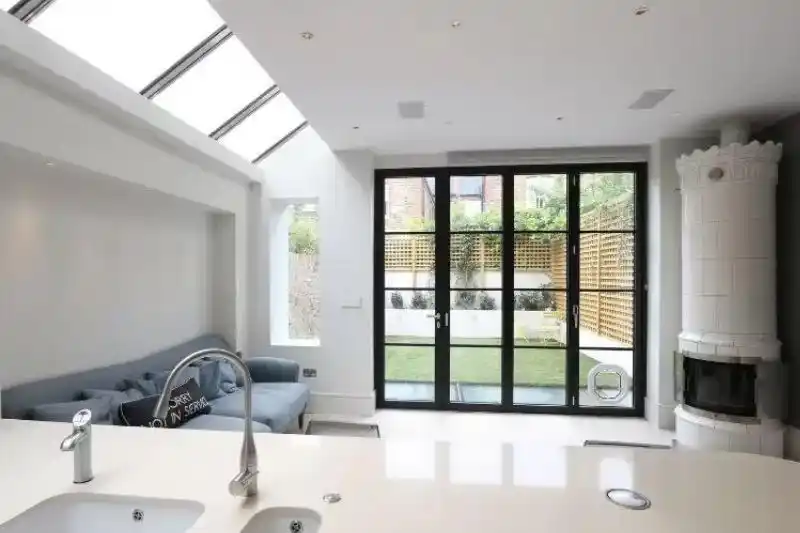 contemporary kitchen extension with modern and minimal design and a black steel look aluminium bifold patio door