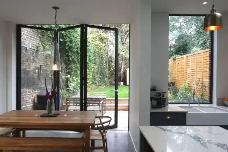 three pane aluminium bifold patio door with dark grey frames in a modern kitchen extension